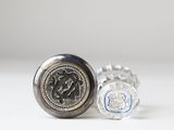 a silver cuff with a coin on it and a silver cuff with a coin on it