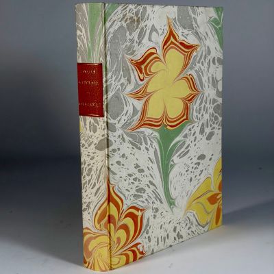 an old book with a yellow flower on it sitting on a table