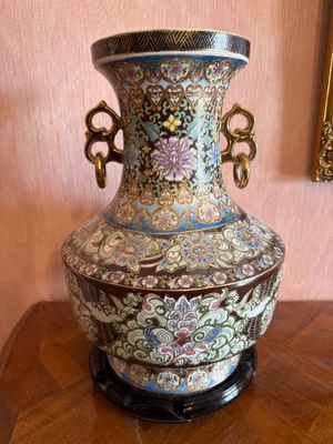 a vase that is sitting on a table in front of a mirror