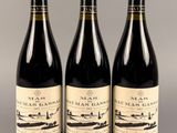 trois bouteilles de vin sont alignées sur une table