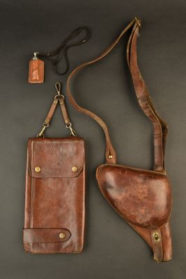 a brown leather case and a brown leather holster on a black background