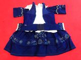 a close up of a blue dress and jacket on a red surface