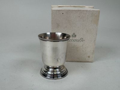 a silver cup sitting next to a box on a table