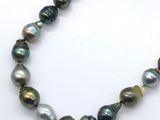 a close up of a necklace on a white surface