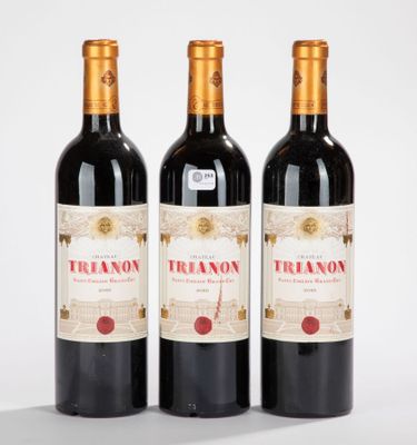 trois bouteilles de vin rouge posées sur une table
