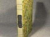an old book sitting on top of a table next to a gray wall