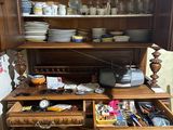 a wooden cabinet with many dishes and cups in it