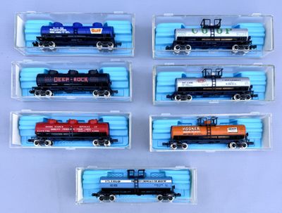 six toy train cars are lined up in a row on a blue surface