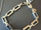 a close up of a metal bracelet on a black leather surface