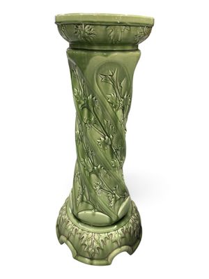 un vase vert posé sur une table blanche