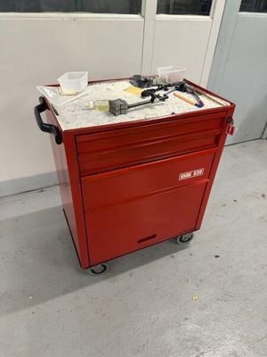 une boîte à outils rouge sur laquelle sont posés des outils