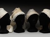 trois têtes de mannequins sont alignées les unes à côté des autres, coiffées de chapeaux