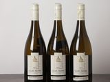 three bottles of wine sitting on top of a wooden table