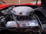 a red car engine with the hood up and the hood down