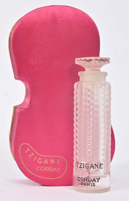 un flacon de parfum à côté d'un étui à violon