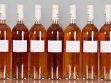 six bottles of wine are lined up in a row on a table