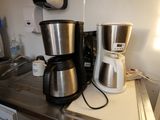 two coffee makers sitting on a counter in a kitchen