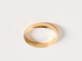gros plan d'une bague en or sur une surface blanche