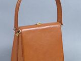 un petit sac à main en cuir beige avec un fermoir doré