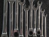 six wrenches sitting on a black surface next to each other