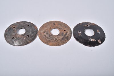 deux vieux anneaux métalliques posés l'un à côté de l'autre sur une surface blanche