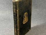 an old book sitting on top of a table next to a gray surface