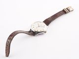 a close up of a watch on a white surface with a white background