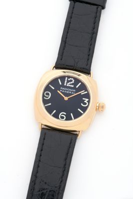 an image of a black and gold wrist watch on a white surface