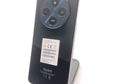the back of a black cell phone with a blue sticker on it