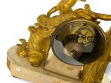 a gold clock that has a statue on top of it