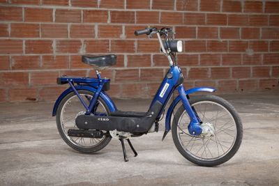 a blue bike parked in front of a brick wall