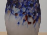 a blue and white vase sitting on a wooden table