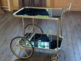 un chariot à boissons doré recouvert d'une serviette noire