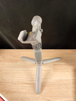 un téléphone portable posé sur un trépied, sur une table
