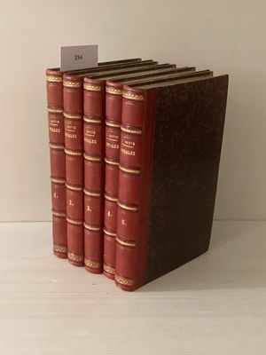 Trois livres rouges sont empilés les uns sur les autres sur une table blanche.