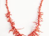 collier composé de perles de corail rouge avec un fermoir en or sur fond blanc