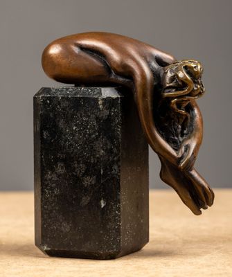 bronze sculpture of a sleeping woman on a black marble block