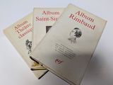 trois livres sont empilés sur une table