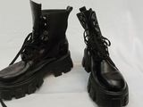 pair of black combat boots with laces on them on a white background