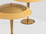 a pair of gold table lamps on a white surface