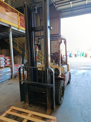un chariot élévateur dans un entrepôt, avec des palettes au premier plan