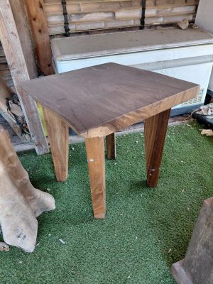 a small wooden table on the grass in front of a building