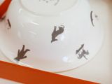 a white bowl with black cats on it in a box