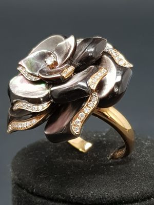 an image of a black and white flower ring on a black surface