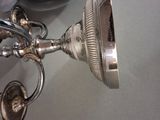 a silver cup on a table next to a silver plate