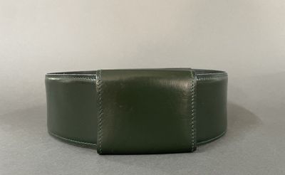 green leather wristband with stitching on a plain surface