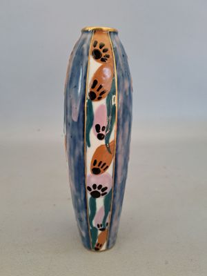 un vase bleu orné d'un motif, posé sur une table