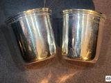 two silver cups sitting on top of a table