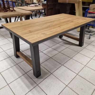 La table est en bois et en métal, avec un plateau en bois.