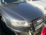 une voiture argentée garée sur un parking, avec d'autres voitures en arrière-plan
